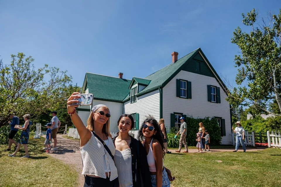 A small tour group standing in front of the Green Gables farmhouse