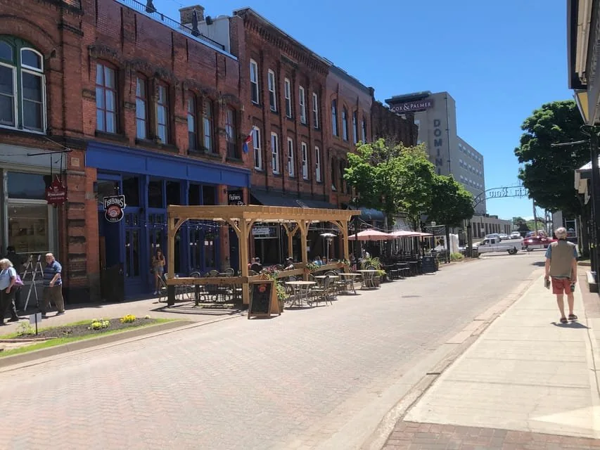 A street of restored brick and wooden buildings with shopfronts in downtown Charlottetown